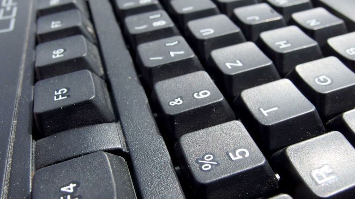 Eine verschmutzte Tastatur wird von oben fotografiert, zeigen die Tasten und ihre Struktur in einem technischen Umfeld.