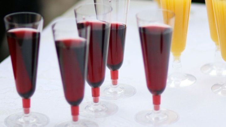 Sechs Gl&auml;ser mit roten Getr&auml;nken stehen auf einem Tisch, w&auml;hrend k&uuml;hle Getr&auml;nke durch Trockeneis pr&auml;sentiert werden.