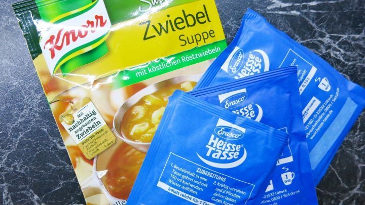 T&uuml;tensuppen liegen auf einer Marmoroberfl&auml;che. Links ist eine Knorr Zwiebelsuppe, rechts blaue Erasco Heisse Tasse Beutel.