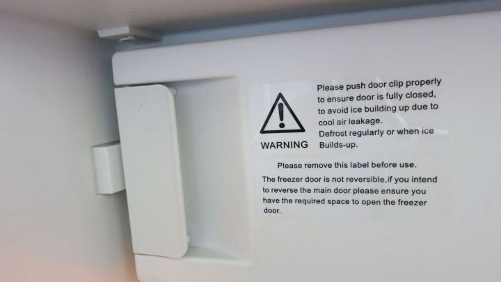 Die Gefrierfachklappe ist abgebrochen und zeigt Anweisungen und Warnungen f&uuml;r den sicheren Gebrauch im Inneren eines K&uuml;hlschranks.