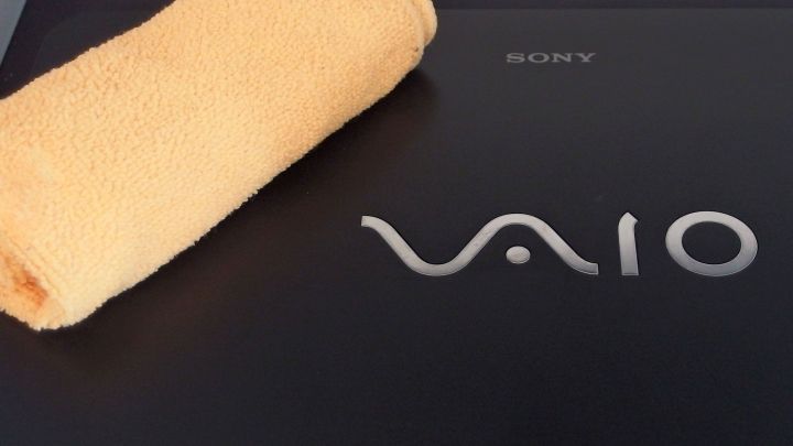 Ein Sony Vaio Notebook liegt auf einer Oberfl&auml;che, w&auml;hrend ein orangefarbenes Tuch daneben f&uuml;r die Reinigung bereitliegt.