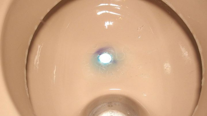 Ein Toilettenbecken zeigt sich mit einem leichten Wasseransatz und sichtbaren Ablagerungen im Inneren.
