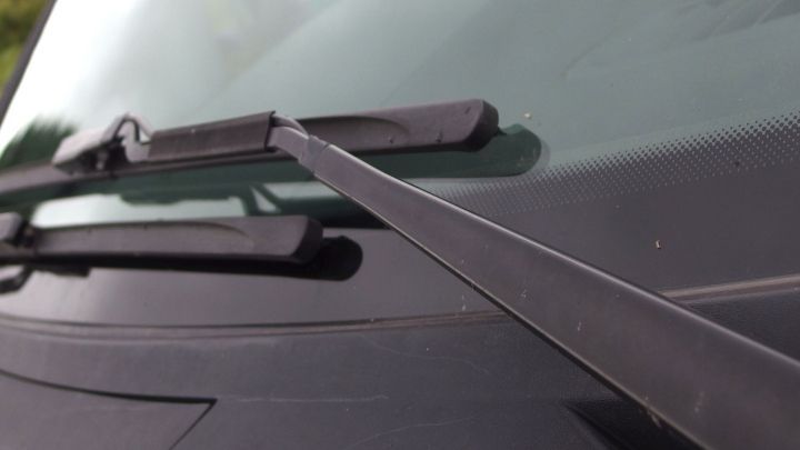 Eine Polizeiautoscheibe mit einem Wischerarm, der sich auf die Scheibe bewegt, um Schmutz zu entfernen.