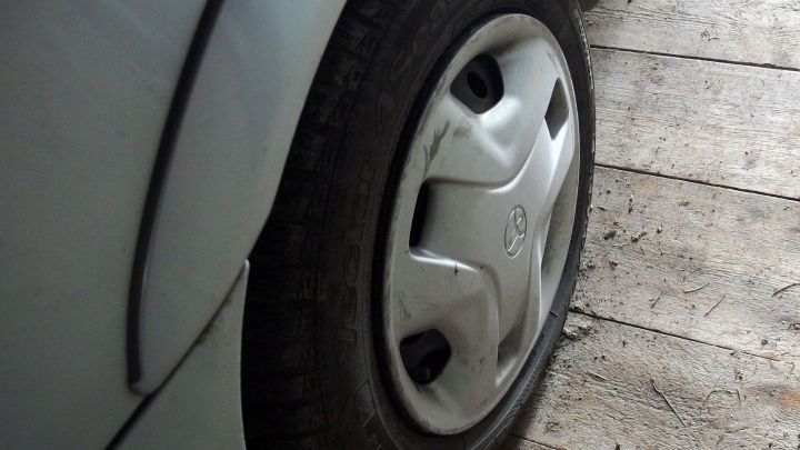 Ein festgerostetes Rad liegt auf einem Holzboden und erfordert spezielle Techniken zur L&ouml;sung ohne Hebeb&uuml;hne.