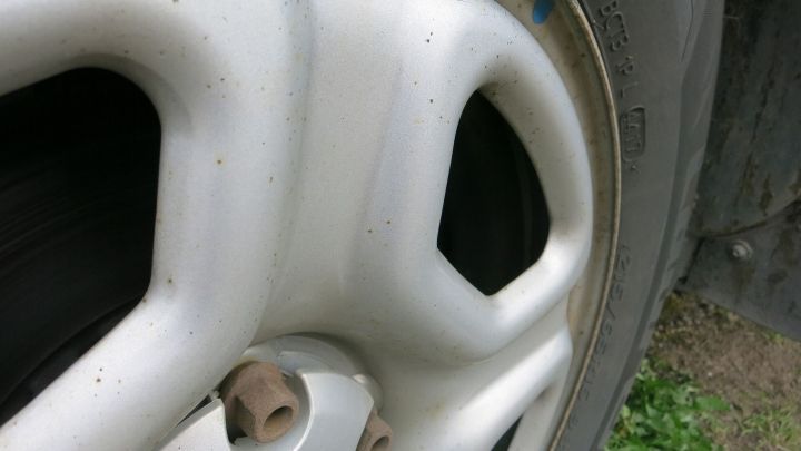 Eine Autofelge, die mit Backofenreiniger behandelt wird, zeigt Schmutz und Ablagerungen im Freien.