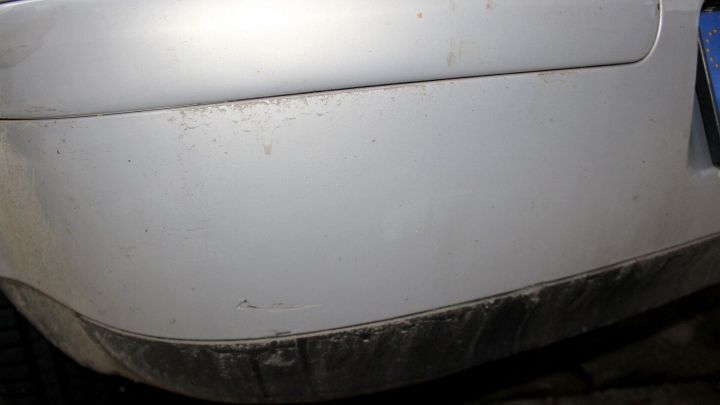Ein Auto mit hartn&auml;ckigem Schmutz am Lack steht im Fokus, sichtbar an der unteren Sto&szlig;stange.