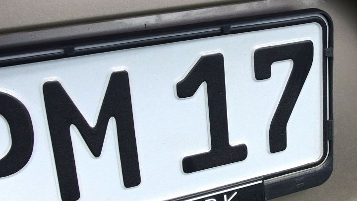Eine Nummernschild mit der Aufschrift "PM 17" ist sichtbar, umgeben von einer hellen Sto&szlig;stange. Insekten sind dort nicht zu sehen.