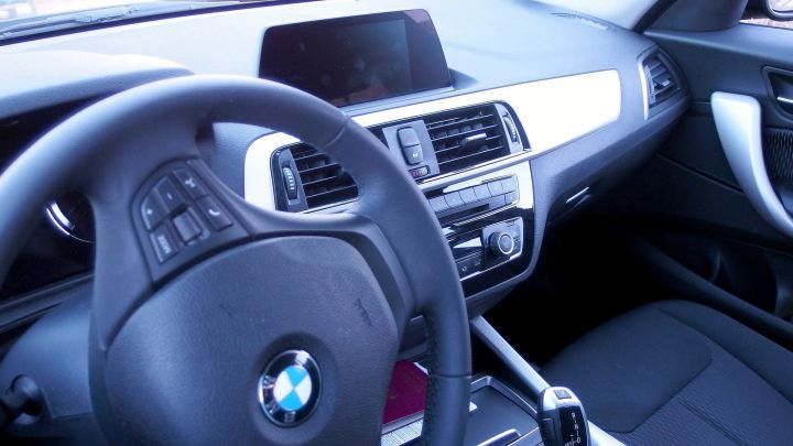 Ein modernes Auto-Interieur zeigt ein sauberes, elegantes Cockpit mit einem BMW-Logo, bereit f&uuml;r eine angenehme Fahrt.