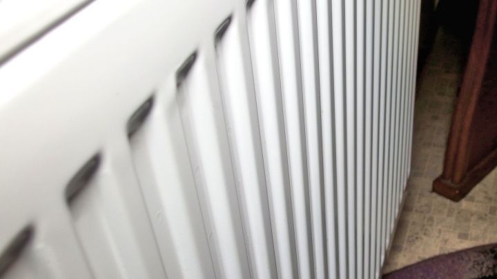 Eine warme Heizung wird sichtbar entlang eines Fensters betrachtet, ideal zum Streichen in einem Raum mit Teppichboden.