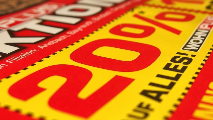 Ein gro&szlig;es, auff&auml;lliges Rabatt-Schild mit "20% Rabatt auf alles!" hebt den Preisvorteil beim rechtzeitigen Kauf hervor.