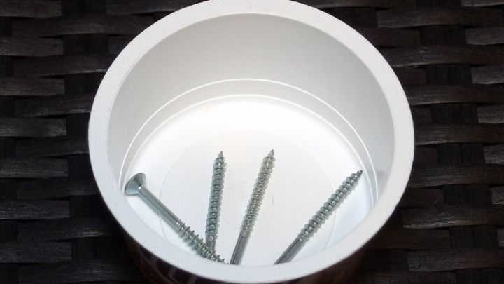 In einem Frischk&auml;sesch&auml;lchen liegen ordentlich sortierte Schrauben. Die Schale ist wei&szlig; und steht auf einem dunklen Untergrund.