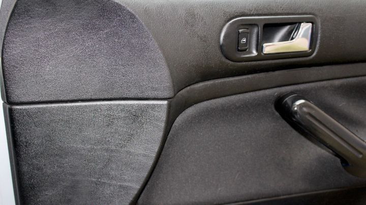 Eine T&uuml;rverkleidung aus Kunststoff, die gereinigt wird, steht im Fokus, um die Farbe des alten Autos aufzufrischen.