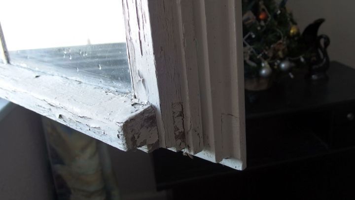 Ein Holzfenster mit sichtbar besch&auml;digtem Rahmen steht offen und zeigt Undichtigkeiten im Innenbereich eines Raumes.