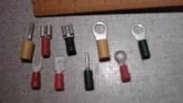 Verschiedene Kabelklemmen liegen nebeneinander auf einer grauen Oberfl&auml;che, mit einem Lineal zur Gr&ouml;&szlig;eneinsch&auml;tzung dar&uuml;ber.