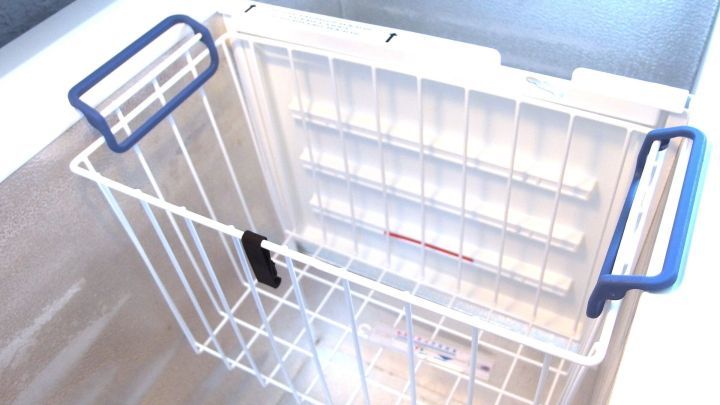 Eine leere K&uuml;hltruhe in einer modernen K&uuml;che zeigt den Korb zum Abtauen und S&auml;ubern, bereit f&uuml;r die Reinigung.