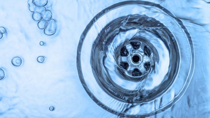 Ein Abfluss in einem Wasserbecken zeigt, wie Sp&uuml;lmittel gegen verstopften Abfluss wirken kann, um das Wasser abflie&szlig;en zu lassen.