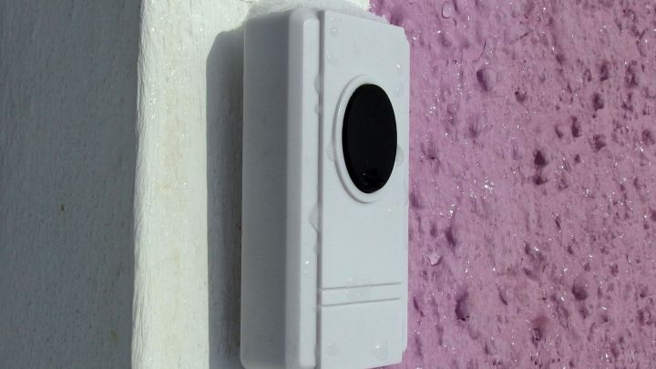 Eine wei&szlig;e Halterung wird an einer lila Wand befestigt, ganz ohne zu bohren, um eine einfache Anbringung zu erm&ouml;glichen.