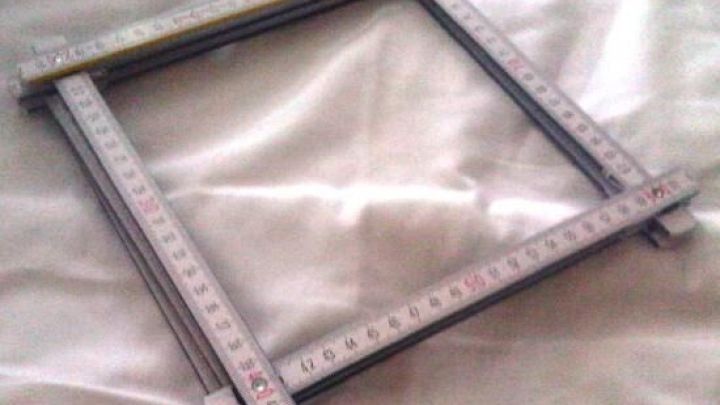 Ein quadratisches Messger&auml;t liegt auf einer gl&auml;nzenden Oberfl&auml;che und misst pr&auml;zise Abst&auml;nde in einem technischen Kontext.