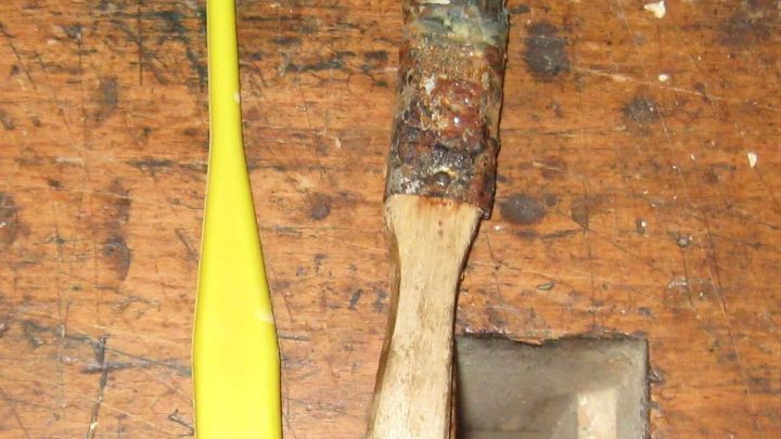 Zwei Pinsel liegen auf einem Holzuntergrund, einer gelb und einer mit Naturhaaren, ideal f&uuml;r Wei&szlig;leim.