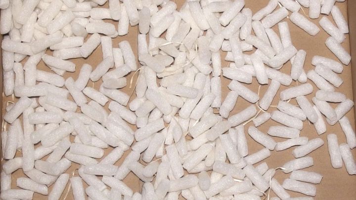 Wei&szlig;e Verpackungsf&uuml;llung liegt verstreut auf einem Karton, ideal um Blumenerde gut durchl&uuml;ften zu k&ouml;nnen und sie zu sch&uuml;tzen.