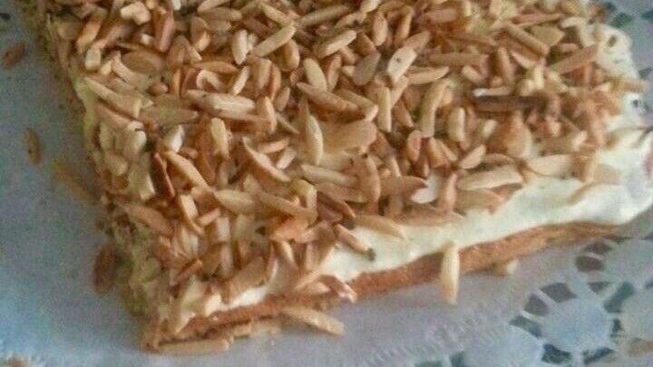 Ein Nusskuchen liegt auf einer zarten, wei&szlig;en Spitze, bedeckt mit ger&ouml;steten N&uuml;ssen, bereit zum Genie&szlig;en.