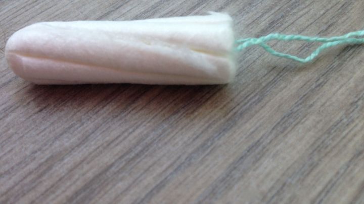 Ein Tampon liegt auf einer Holzoberfl&auml;che und wird als Werkzeug zum Fensterrahmen reinigen verwendet.