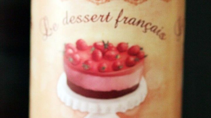 Ein dekorativer Keksbeh&auml;lter steht neben zwei kleinen Portionen Karamell-Popcorn auf einer pinken Fl&auml;che.