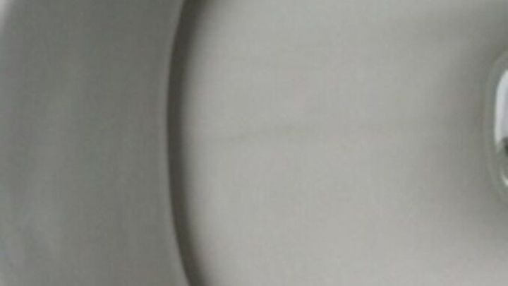 Eine glatte, wei&szlig;e Keramikoberfl&auml;che zeigt einen klaren Wasserstrom, w&auml;hrend Urinstein und Kalk entfernt werden.