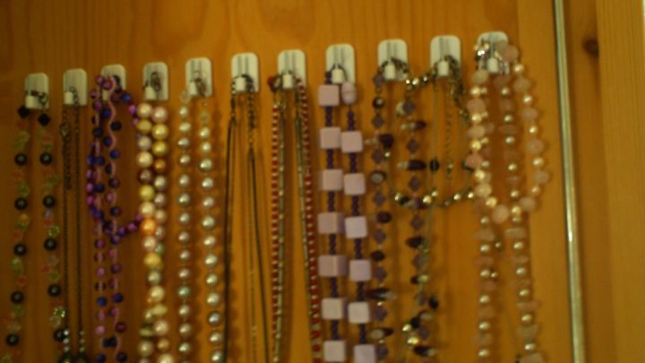 Modeschmuck Ketten h&auml;ngen ordentlich an einer Wand, gut sichtbar sortiert, um einen &uuml;bersichtlichen Blick zu bieten.