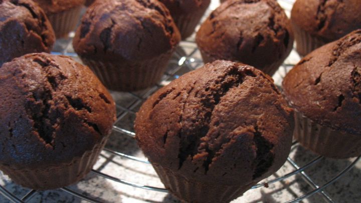 Schoko-Muffins k&uuml;hlen auf einem Metallgitter ab, frisch gebacken in einer K&uuml;che auf einer Arbeitsplatte.