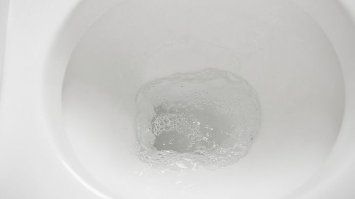 Eine Tiefsp&uuml;ltoilette zeigt einen kreisenden Wasserstrahl im Wasser, der Spritzer im Badezimmer verhindert.