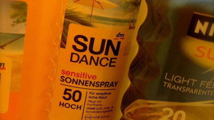 Drei Flaschen Sonnencreme stehen nebeneinander, bereit f&uuml;r den Sommer, um Sonnenstrahlen zu blockieren und die Haut zu sch&uuml;tzen.