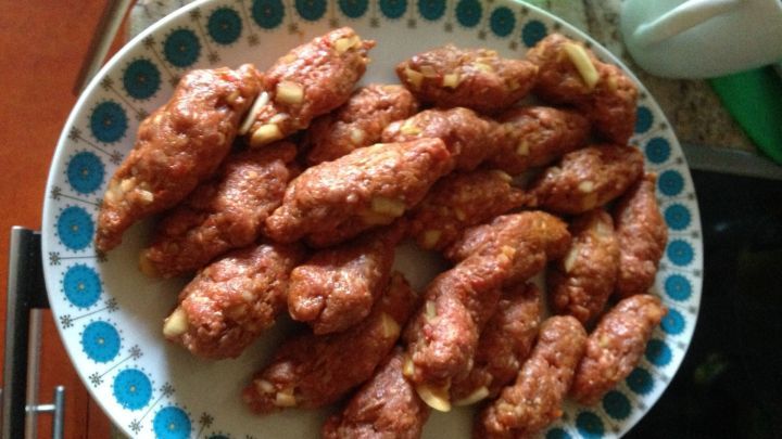 Zwiebelhackr&ouml;llchen liegen auf einem bunten Teller und sind goldbraun gebraten, bereit zum Servieren.