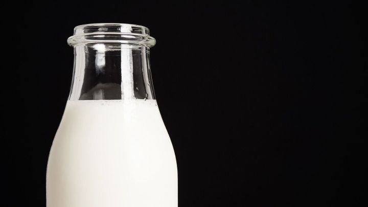 Ein Glas frisch homogenisierte Milch steht auf einem dunklen Hintergrund, perfekt f&uuml;r die Diskussion &uuml;ber Milchunvertr&auml;glichkeit.