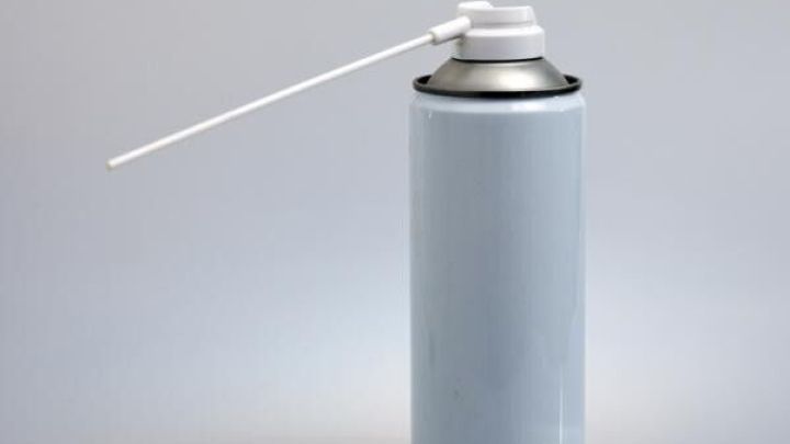 Spr&uuml;hdose mit langem R&ouml;hrchen-Aufsatz, steht auf grauem Hintergrund, ideal gegen quietschende T&uuml;ren und festgerostete Schrauben.