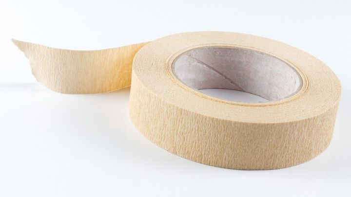 Eine Rolle Kreppband liegt bereit, w&auml;hrend ein St&uuml;ck abgerollt wird, um Etiketten zum Einfrieren anzubringen.