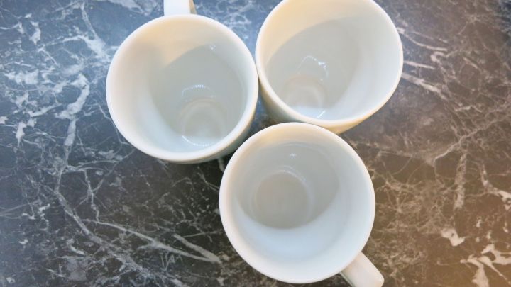 Drei leere Teetassen stehen auf einer marmorierten Oberfl&auml;che und warten darauf, geputzt zu werden.