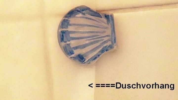 Eine selbstklebende Klemme h&auml;lt den Duschvorhang an Ort und Stelle, w&auml;hrend sie an einer Wand befestigt ist.