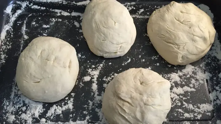 Die Teigb&auml;llchen auf eine bemehlte Fl&auml;che geben