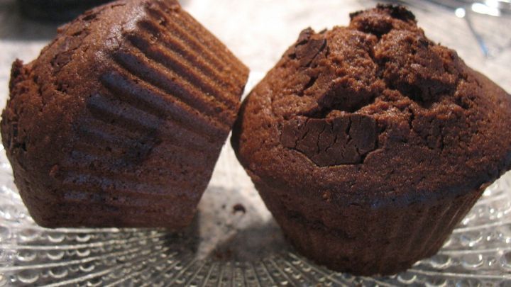 Delicate Schoko-Muffins stehen auf einem Glasplatte, frisch gebacken und bereit zum Genie&szlig;en, mit einer leckeren Nougat-F&uuml;llung.