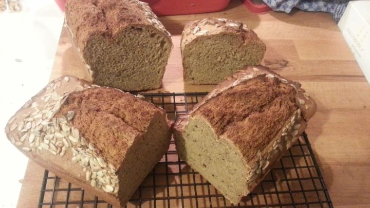 Frisches Dinkelbrot liegt auf einem Kuchengitter, w&auml;hrend ein lauwarmer Raum eine heimelige Atmosph&auml;re schafft.