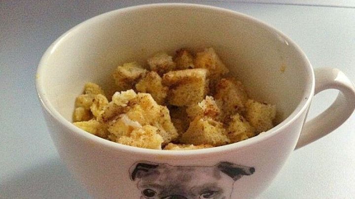 In einer Tasse mit einem Hundemotiv liegen kleine St&uuml;cke von French Toast, bereit zum Genie&szlig;en.