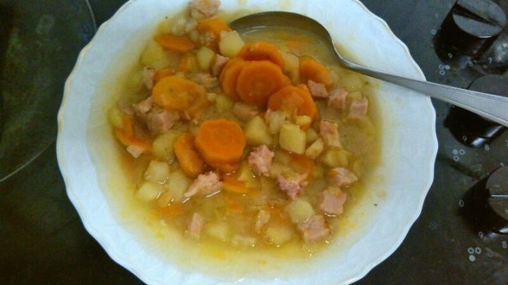Eine k&ouml;stliche M&ouml;hrensuppe mit Putenfleischeinlage steht in einer Sch&uuml;ssel auf einer K&uuml;chenoberfl&auml;che, garniert mit Karottenst&uuml;cken.
