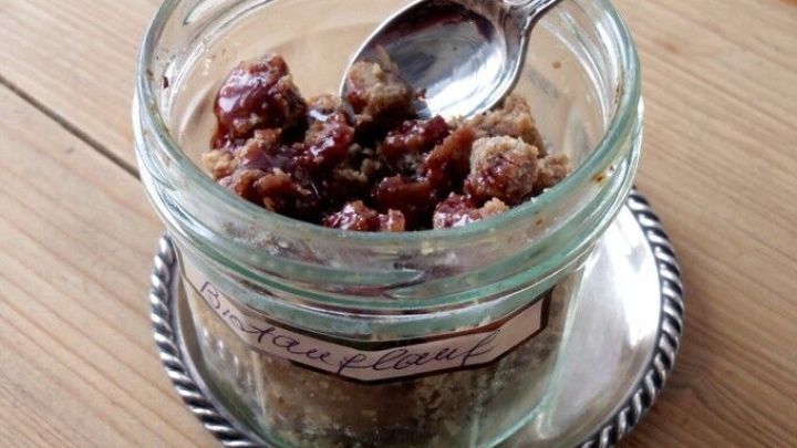 Ein Glas mit Brotauflauf enth&auml;lt St&uuml;cke von misslungenem Hefebrot, w&auml;hrend ein L&ouml;ffel darin ruht, auf einem Tablett.