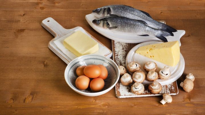 Frischer Fisch und Eier liegen auf dem Tisch, umgeben von Butter und Champignons, ideal f&uuml;r Vitamin D-reiche Mahlzeiten.