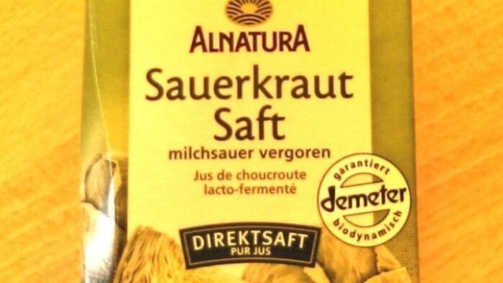 Eine Verpackung von Sauerkrautsaft steht auf einem Holztisch. Der Saft soll eine milchsaure Verg&auml;rung f&ouml;rdern.