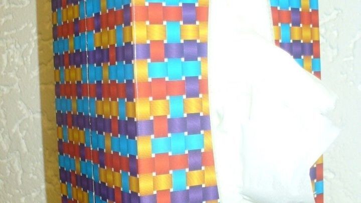 Eine bunten Kosmetikt&uuml;cherbox steht auf einem Tisch, aus der ein Taschentuch herausgezogen wird, ideal bei Schnupfen.