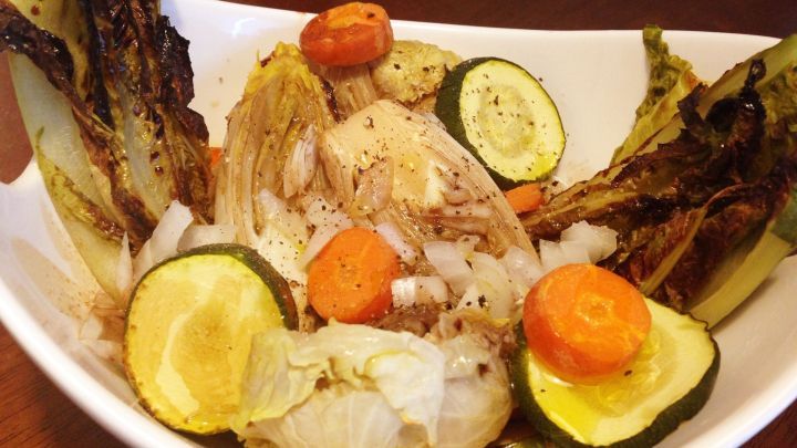 Ein bunter Teller mit gegrilltem Gem&uuml;se, darunter Zucchini, Karotten und Blattsalat, pr&auml;sentiert eine appetitliche vegetarische Speise.