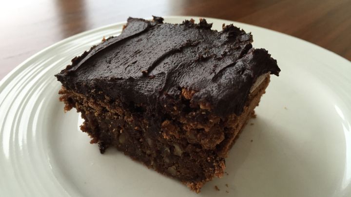 Schokolade-Brownie liegt auf einem wei&szlig;en Teller und wartet darauf, serviert und genossen zu werden.