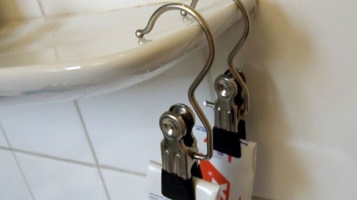 Klammerhaken h&auml;ngen an der Wand und halten verschiedene Gegenst&auml;nde, w&auml;hrend sie an einem kleinen Regal angebracht sind.